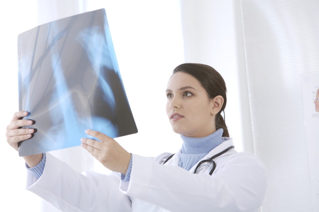 A female doctor examines an X-ray, focusing intently on the details,